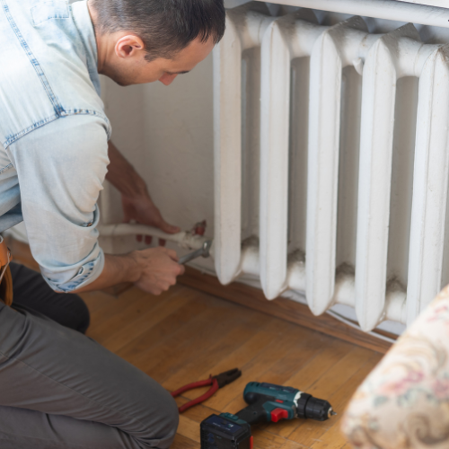 Jack The Plumber's heating technician diagnosing radiator issues and providing efficient repair solutions in Birmingham.