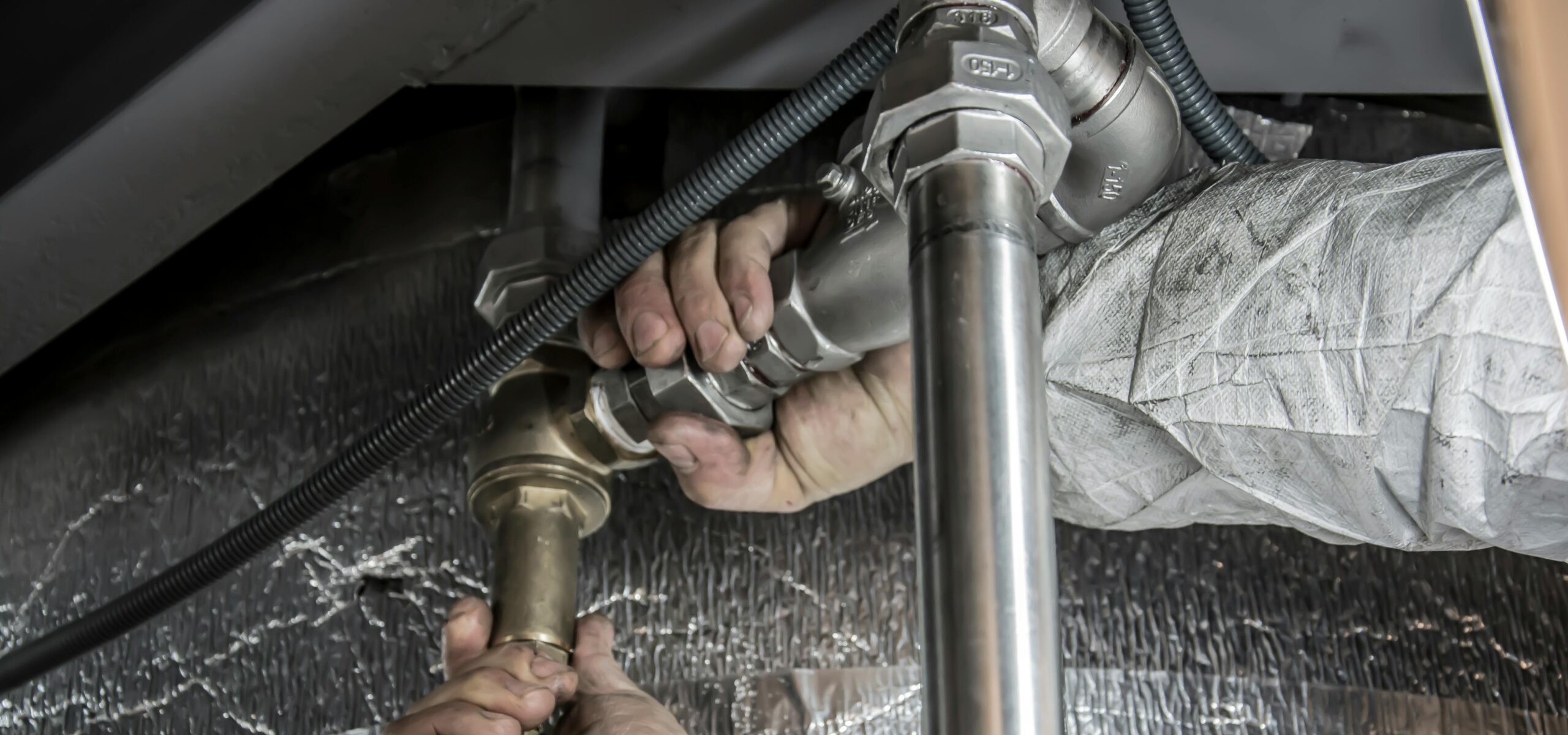 Jack The Plumber emergency plumbing service technician fixing a burst pipe in a Birmingham home.